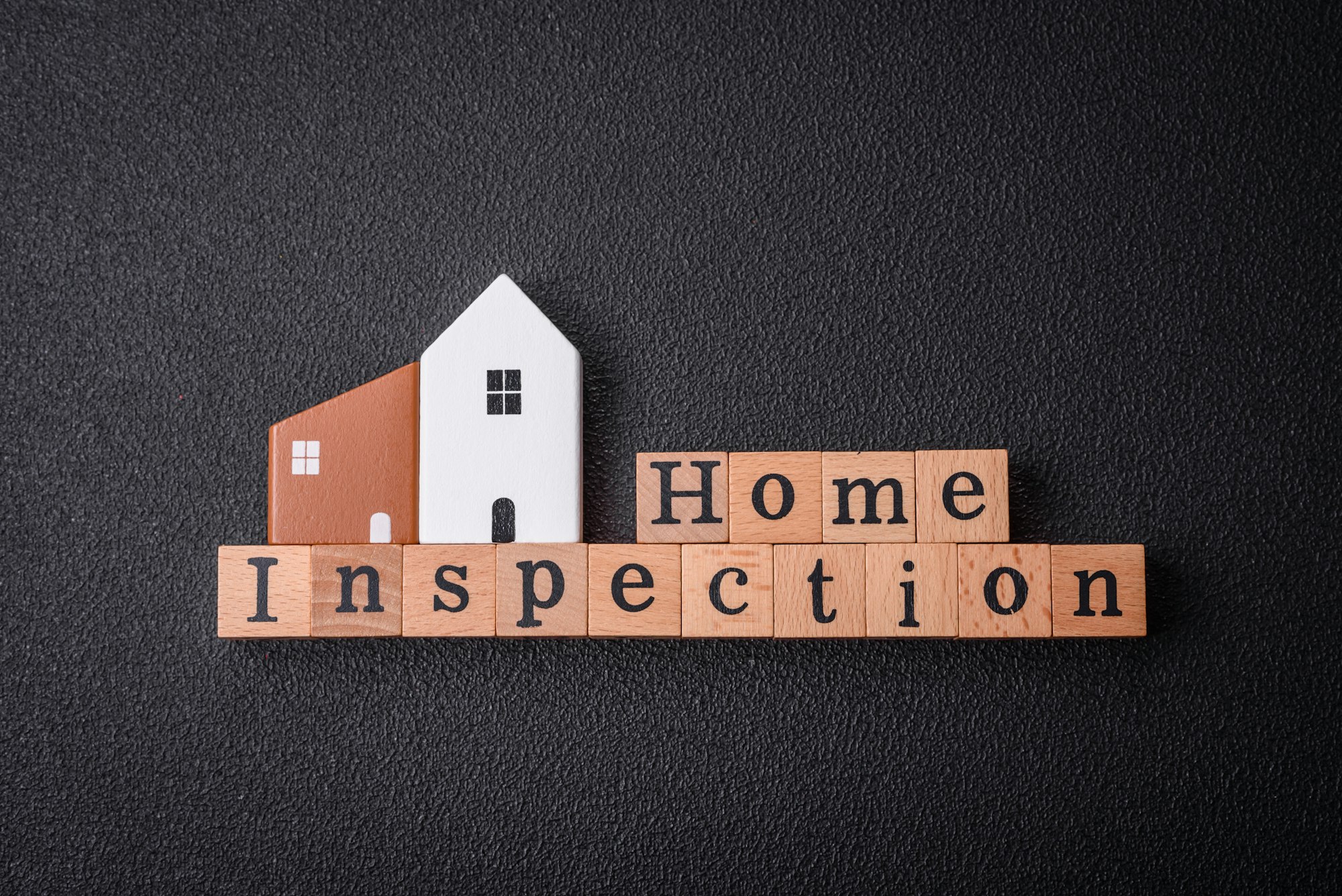 The inscription Home inspection made of wooden cubes on a plain background