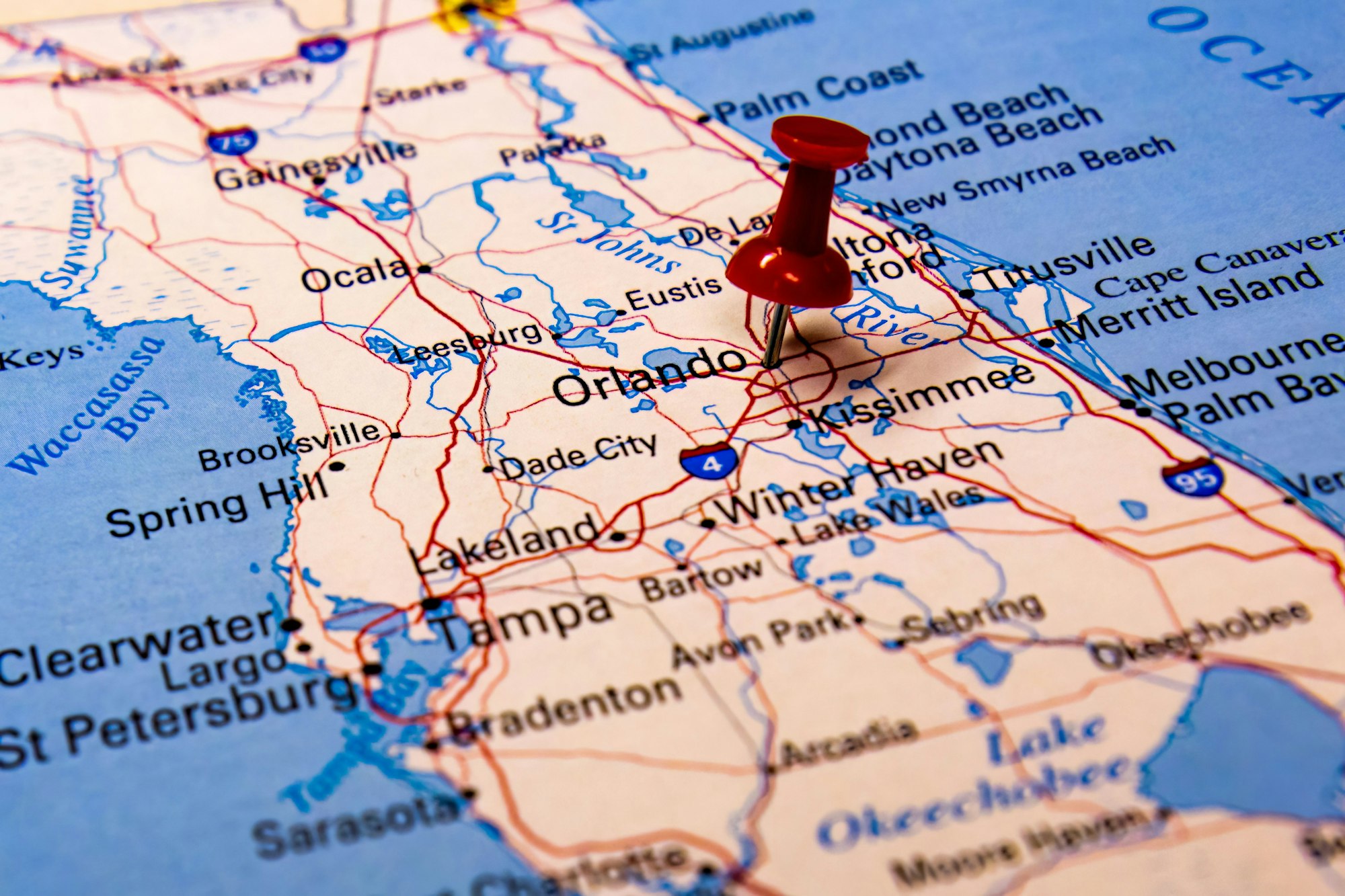 Closeup shot of a traveling red push pin on a map on the city of Orlando